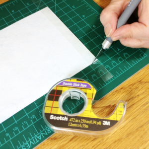 Here I am trimming the double sided tape to the height of the paper.